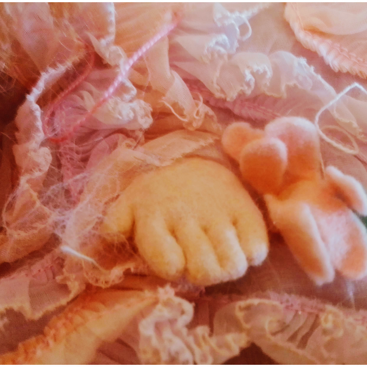 Muñeca antigua coleccion lenci. Primer plano de manos de fieltro y vestido rosa con volantes, muñeca de La Casa de los Laureles